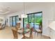 Dining area with glass table next to large sliding glass doors leading to a backyard patio at 15605 Derna Ter, Bradenton, FL 34211