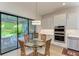 Dining area featuring glass table next to backyard patio access and kitchen area at 15605 Derna Ter, Bradenton, FL 34211