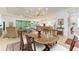 Open-concept dining room with hardwood table, chandelier, and views of the living room and kitchen at 15605 Derna Ter, Bradenton, FL 34211