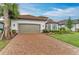 Attractive home exterior with a red tile roof, brick driveway, and two-car garage at 15605 Derna Ter, Bradenton, FL 34211
