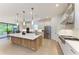 Bright kitchen with white cabinets, stainless steel appliances, and a large center island with seating at 15605 Derna Ter, Bradenton, FL 34211