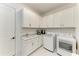 Bright laundry room with white cabinets, sink and modern washer and dryer at 15605 Derna Ter, Bradenton, FL 34211