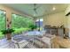Enclosed patio with ceiling fan, dining set, built-in grill, and serene views of the backyard at 15605 Derna Ter, Bradenton, FL 34211