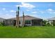 View of a large backyard with tropical landscaping and screened in lanai at 16234 Isola Pl, Bradenton, FL 34211