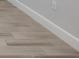 Close up of light wood-look tile floor with white baseboards and an electrical outlet at 16234 Isola Pl, Bradenton, FL 34211
