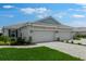 Beige home featuring a two-car garage and lush, green front lawn at 16234 Isola Pl, Bradenton, FL 34211