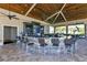 Outdoor bar area with seating, TVs, and a well-stocked bar, perfect for entertaining in a relaxed setting at 18113 Gawthrop Drive # 101, Lakewood Ranch, FL 34211