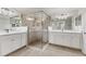 Modern bathroom with dual sinks, white cabinetry, and a frameless glass shower at 18113 Gawthrop Drive # 101, Lakewood Ranch, FL 34211