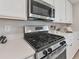 Contemporary gas range and microwave with white cabinets at 18113 Gawthrop Drive # 101, Lakewood Ranch, FL 34211