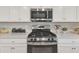 Close-up of stainless steel gas range and microwave with white cabinets at 18113 Gawthrop Drive # 101, Lakewood Ranch, FL 34211