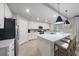 Contemporary kitchen with white cabinetry, modern appliances, and a spacious island with seating at 18113 Gawthrop Drive # 101, Lakewood Ranch, FL 34211