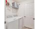 Well-equipped laundry room with washer and dryer and white shelving at 18113 Gawthrop Drive # 101, Lakewood Ranch, FL 34211