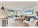 Bright and airy living room featuring neutral decor, tile floors, and sliding glass doors at 18113 Gawthrop Drive # 101, Lakewood Ranch, FL 34211