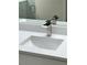 Close-up of a modern bathroom sink with white countertop and chrome faucet fixture at 18113 Gawthrop Drive # 101, Lakewood Ranch, FL 34211