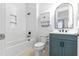 Bright bathroom features a white tub with tile surround, matte black fixtures, and blue vanity at 18215 Cayo Largo Pl, Bradenton, FL 34202