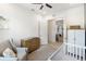Bright Bedroom with grey glider, light wood floors, and a serene, minimalist design at 18215 Cayo Largo Pl, Bradenton, FL 34202