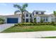 Beautiful two-story home with a well-manicured lawn, blue shutters, and a dark blue garage door at 18215 Cayo Largo Pl, Bradenton, FL 34202