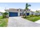 Spacious two-story home with a three-car garage, manicured lawn, and lush landscaping at 18215 Cayo Largo Pl, Bradenton, FL 34202