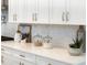 Bright kitchen detail features white cabinets, quartz countertop, and designer backsplash at 18215 Cayo Largo Pl, Bradenton, FL 34202