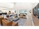 Spacious living room with modern decor, including plush sofas, a textured rug, and views of the pool area at 18215 Cayo Largo Pl, Bradenton, FL 34202