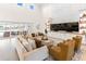 Large living room with high ceilings, integrated cabinets, and a cozy seating area with sliding glass doors to the pool at 18215 Cayo Largo Pl, Bradenton, FL 34202