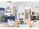 Open-concept living room with white chairs, custom blue cabinets, and a beverage center at 18215 Cayo Largo Pl, Bradenton, FL 34202