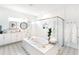 Luxurious main bathroom with a freestanding tub, a glass shower, and patterned tile flooring at 18215 Cayo Largo Pl, Bradenton, FL 34202