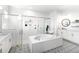 Beautiful bathroom featuring a standalone tub, glass shower, and elegant patterned tile floors at 18215 Cayo Largo Pl, Bradenton, FL 34202