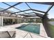 The screened-in outdoor space features a large pool, several seating areas, and a playground at 18215 Cayo Largo Pl, Bradenton, FL 34202