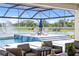 Resort style backyard features covered patio, outdoor seating, waterfall feature, and lake views at 18215 Cayo Largo Pl, Bradenton, FL 34202