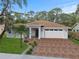 Charming single-story home with a brick driveway, manicured lawn, and decorative landscaping at 2141 Cork Oak St, Sarasota, FL 34232