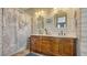 Dual sink bathroom with wooden cabinets, and mirrors and a shower with ocean themed curtain at 220 36Th St, Holmes Beach, FL 34217