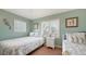 Serene bedroom with twin beds, pastel walls, and sun-filled windows at 220 36Th St, Holmes Beach, FL 34217
