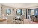 Comfortable dining area with a modern chandelier, blue drapes, and outdoor access at 220 36Th St, Holmes Beach, FL 34217