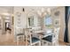 Coastal dining room with white chairs, blue accents, decorative chandelier, and a decorative arched mirror at 220 36Th St, Holmes Beach, FL 34217