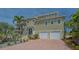 Inviting two-story home featuring a brick driveway and a two-car garage at 220 36Th St, Holmes Beach, FL 34217