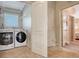 Bright laundry room with modern washer and dryer, storage shelves, and neutral tile flooring for easy maintenance at 220 36Th St, Holmes Beach, FL 34217