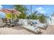 Relaxing patio area featuring lounge chairs, umbrella and outdoor seating surrounded by lush tropical landscaping at 220 36Th St, Holmes Beach, FL 34217