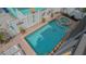 Aerial view of the pool and spa, surrounded by a brick-paved patio and tropical landscaping at 220 36Th St, Holmes Beach, FL 34217