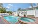 Inviting pool and spa combo with dolphin mosaic tiles, and a brick-paved surround at 220 36Th St, Holmes Beach, FL 34217