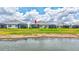 A serene view from behind the home, showcasing a lush lawn and a tranquil pond at 251 Okeeffe Cir, Bradenton, FL 34212