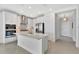 Modern white kitchen with stainless steel appliances, a large island, and a view of the home's entry at 251 Okeeffe Cir, Bradenton, FL 34212