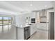 Open-concept kitchen with white cabinets, island, and stainless steel appliances in a well-lit space at 251 Okeeffe Cir, Bradenton, FL 34212