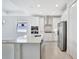 Contemporary white kitchen with an island, stainless appliances, and abundant natural light at 251 Okeeffe Cir, Bradenton, FL 34212