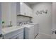 Functional laundry room with appliances, storage cabinets, and a utility sink for convenience at 251 Okeeffe Cir, Bradenton, FL 34212