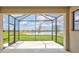 Screened patio overlooking lush green lawn and tranquil lake, offering serene outdoor living at 251 Okeeffe Cir, Bradenton, FL 34212
