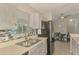 Bright kitchen view featuring stainless steel sink, stainless appliances, cabinets and tiled backsplash at 2759 Starview Ave, North Port, FL 34288