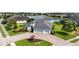 Aerial view of a beautiful home with three-car garage and colorful landscaping, with a pond nearby at 308 Chantilly Trl, Bradenton, FL 34212