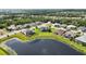 A beautiful home with screened pool sits on a large lot surrounded by green grass near a lake and neighborhood at 308 Chantilly Trl, Bradenton, FL 34212