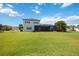 Spacious backyard with a large grassy area, screened pool, and lush tropical landscaping, perfect for outdoor enjoyment at 308 Chantilly Trl, Bradenton, FL 34212